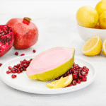Sorbet Pomegranate Lemon Island Way sur assiette blanche avec citron frais et graines de grenade