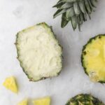 Sorbet Piña Colada Island Way dans une coque d’ananas, en décor blanc marbré avec morceaux d’ananas frais